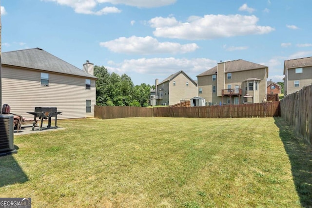 view of yard with a residential view and central AC unit