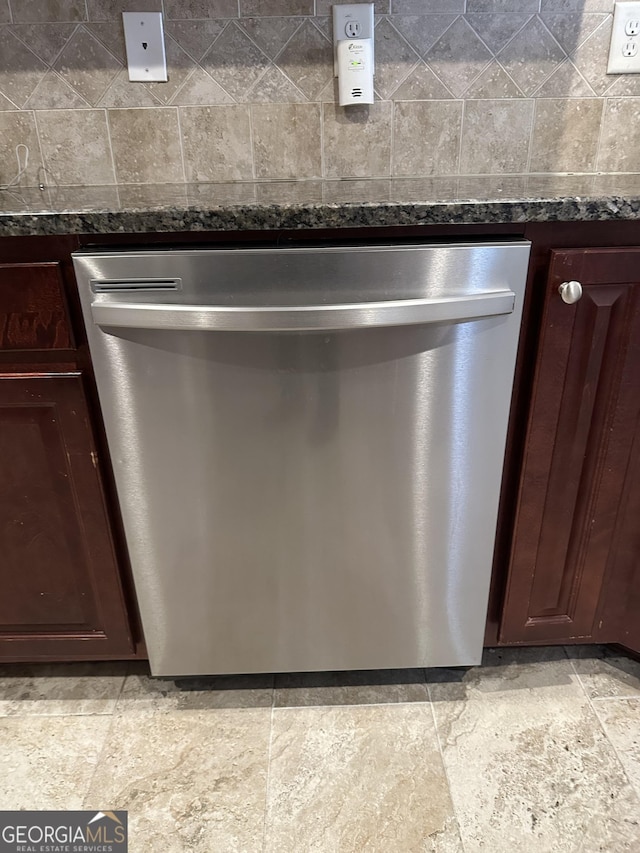 kitchen view of dishwasher, dark brown cabinetry, and dark stone counters