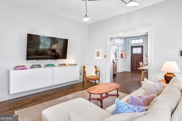 living room with dark wood-type flooring and a textured ceiling