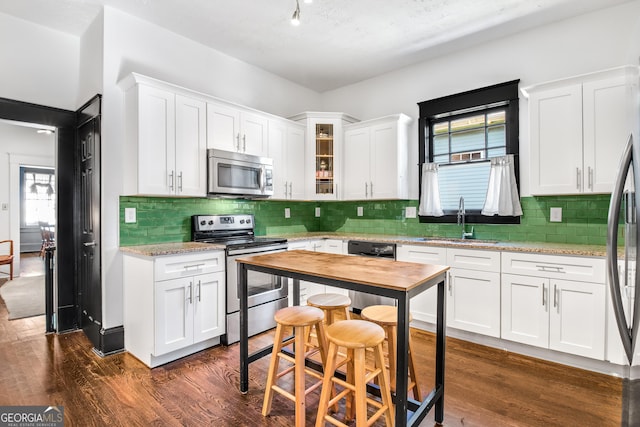 kitchen featuring sink, light stone counters, white cabinets, and stainless steel appliances