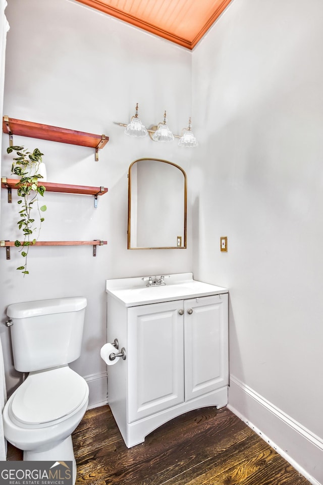 bathroom featuring hardwood / wood-style floors, toilet, vanity, and ornamental molding