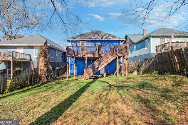 rear view of property with a wooden deck and a yard