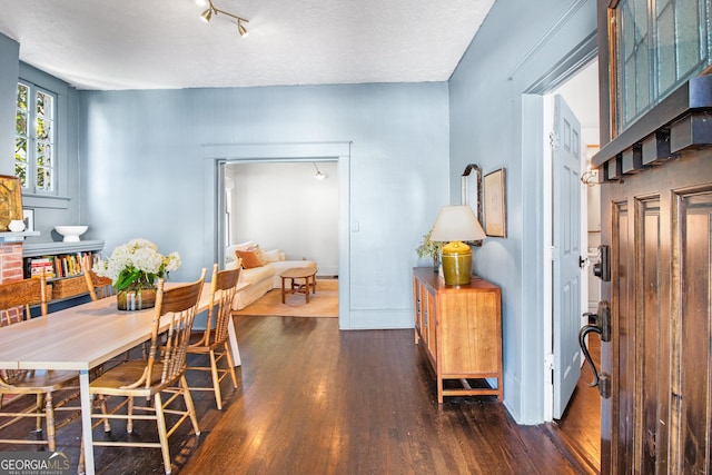 dining space with dark hardwood / wood-style floors and a textured ceiling