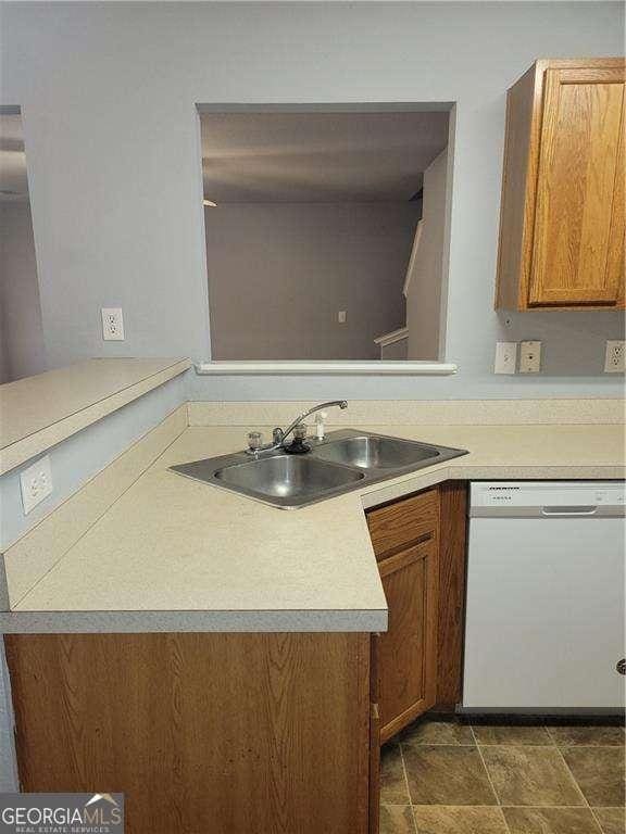 kitchen featuring kitchen peninsula, white dishwasher, and sink