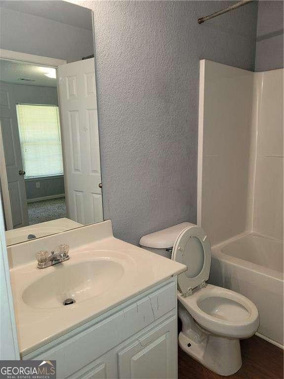 full bathroom featuring vanity, toilet, and bathing tub / shower combination