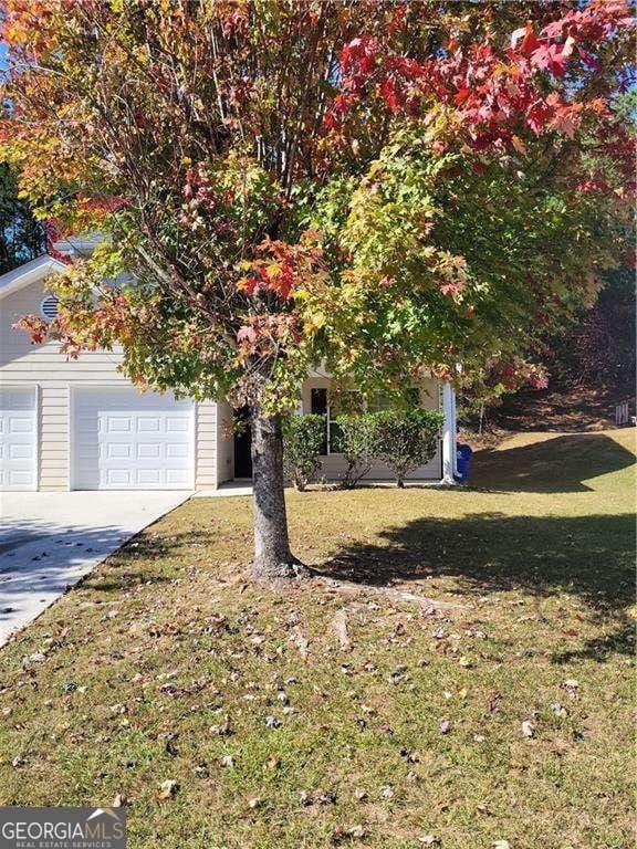 obstructed view of property featuring a garage and a front lawn