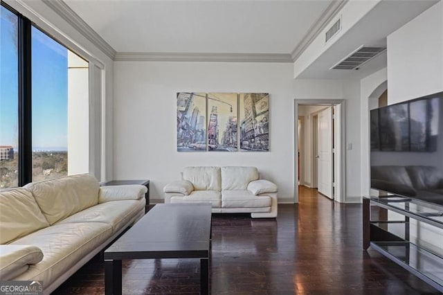 living room featuring plenty of natural light, dark wood-type flooring, and ornamental molding