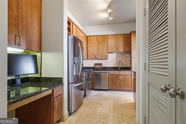 kitchen with decorative backsplash, appliances with stainless steel finishes, dark stone counters, and sink