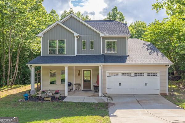 192 Celestial Run, Winder, GA 30680 - view of front facade with a porch, driveway, a front yard, board and batten siding, and a garage