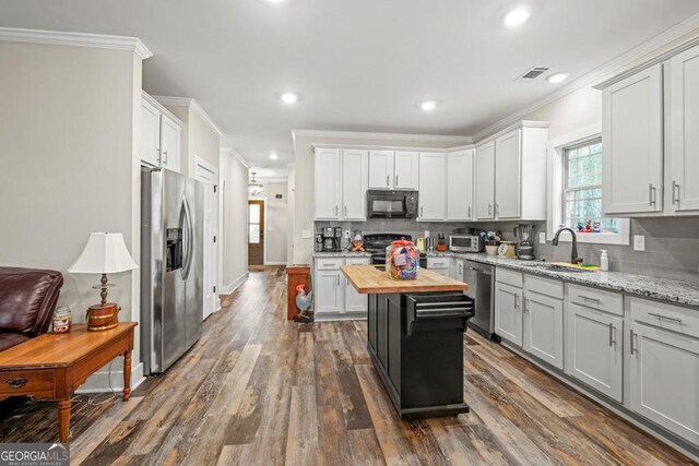 192 Celestial Run, Winder, GA 30680 - kitchen with stainless steel appliances, a sink, butcher block countertops, ornamental molding, and dark wood-type flooring