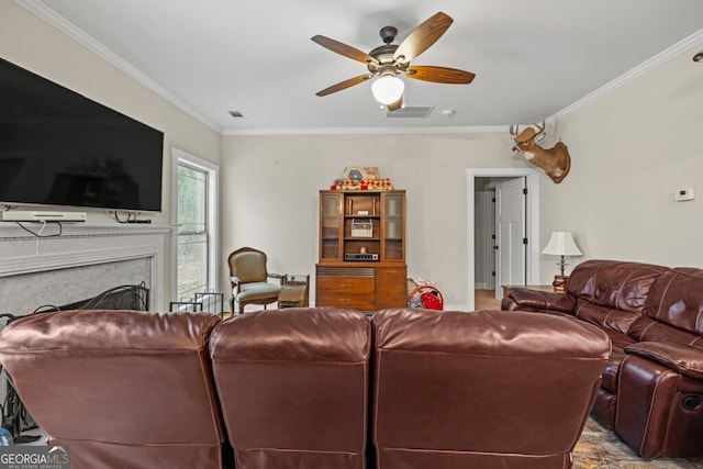 living room featuring a high end fireplace, crown molding, and ceiling fan