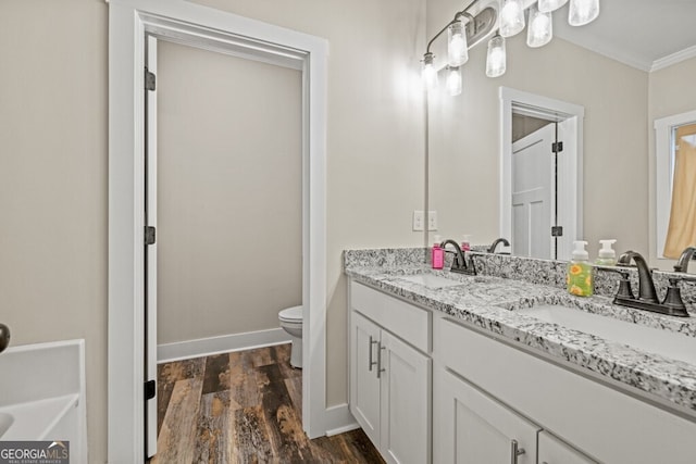 bathroom featuring hardwood / wood-style floors, vanity, toilet, and crown molding