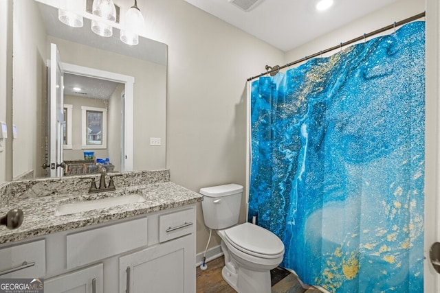 bathroom with a shower with shower curtain, vanity, and toilet