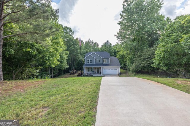 192 Celestial Run, Winder, GA 30680 - view of front of house with driveway, a front yard, an attached garage, a porch, and a view of trees