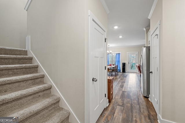 hall featuring dark hardwood / wood-style flooring, an inviting chandelier, and ornamental molding