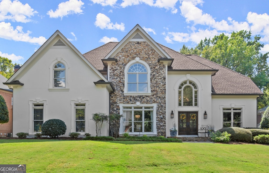 view of front of property featuring a front yard and french doors