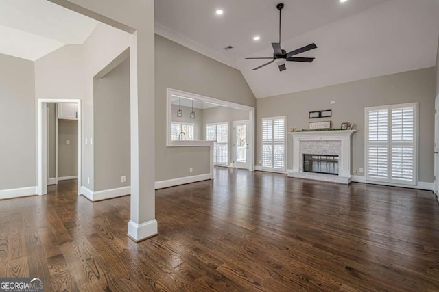 unfurnished living room with ceiling fan, dark hardwood / wood-style flooring, plenty of natural light, and a brick fireplace