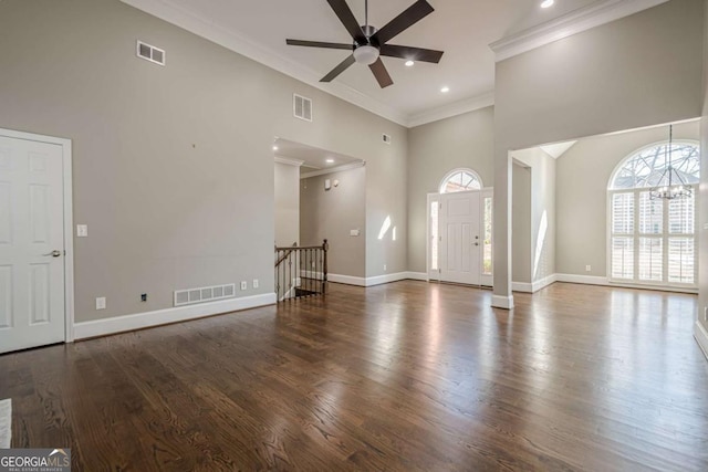 unfurnished living room with ceiling fan, plenty of natural light, and a high ceiling