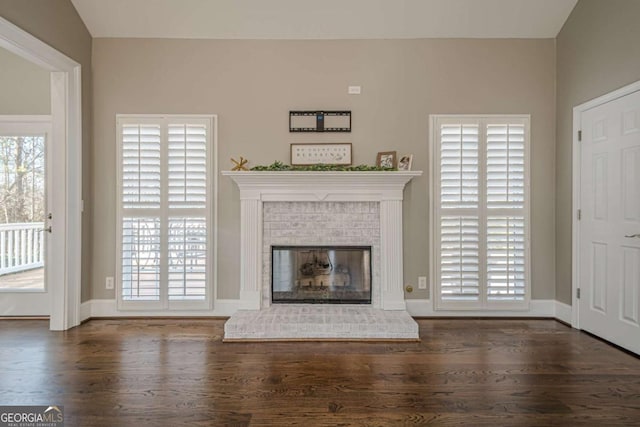 unfurnished living room with lofted ceiling, dark hardwood / wood-style floors, and a brick fireplace