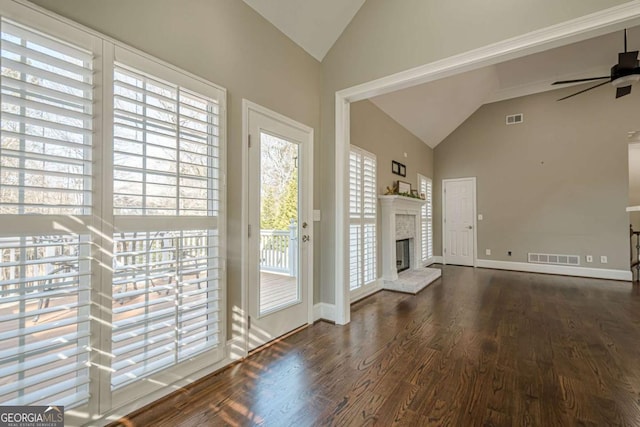 unfurnished living room with ceiling fan, dark hardwood / wood-style flooring, and vaulted ceiling