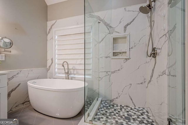 bathroom with tile walls and independent shower and bath