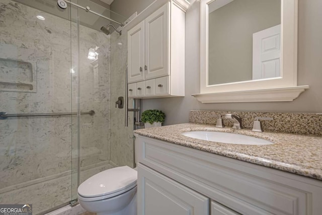 bathroom featuring vanity, toilet, and walk in shower