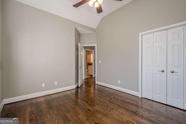 unfurnished bedroom featuring ceiling fan, lofted ceiling, dark wood-type flooring, and a closet