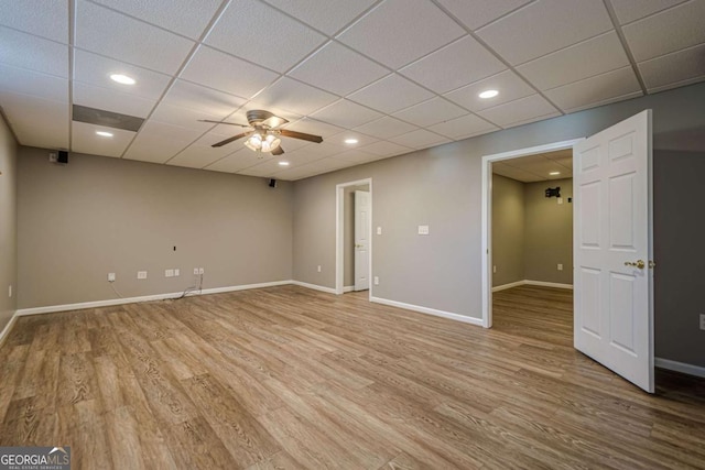 spare room featuring hardwood / wood-style flooring, a drop ceiling, and ceiling fan