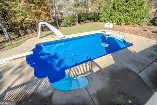 view of pool featuring a diving board, a patio, and a water slide