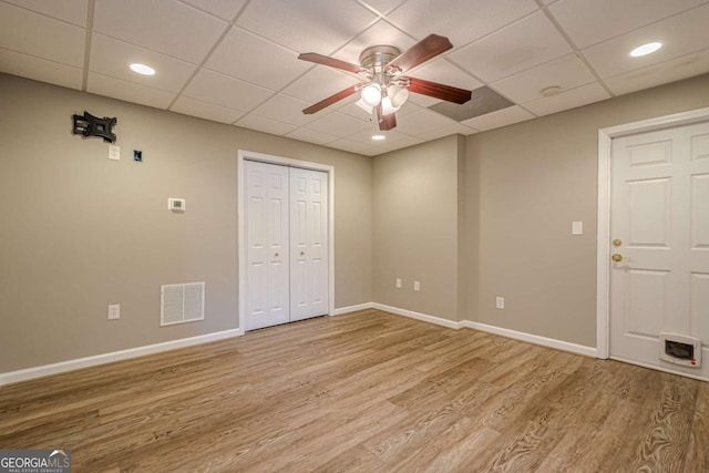 unfurnished bedroom featuring hardwood / wood-style floors, ceiling fan, and a drop ceiling