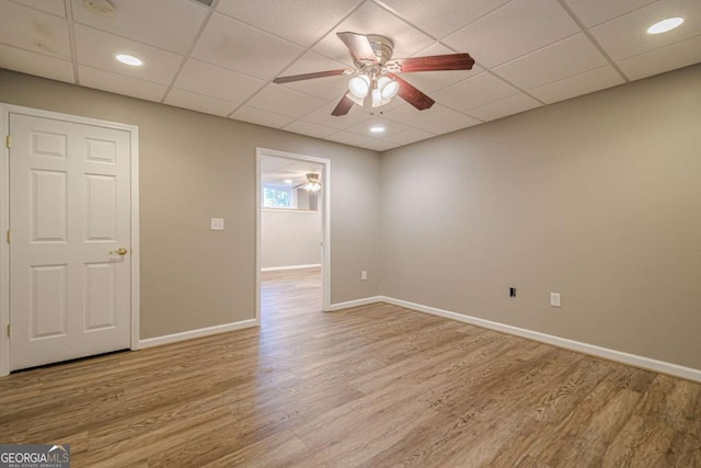 unfurnished room with a paneled ceiling, ceiling fan, and light hardwood / wood-style flooring