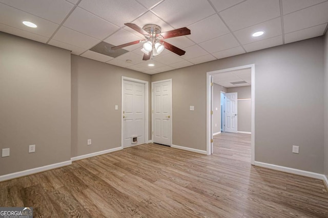 unfurnished room featuring ceiling fan, a drop ceiling, and wood-type flooring