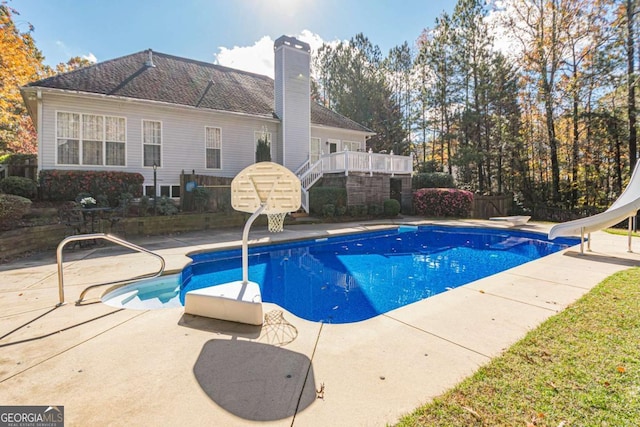 view of pool with a diving board, a patio area, and a water slide