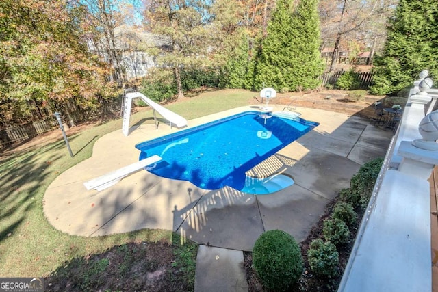 view of pool featuring a yard, a diving board, and a water slide