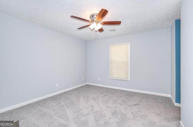 carpeted empty room featuring ceiling fan and a textured ceiling