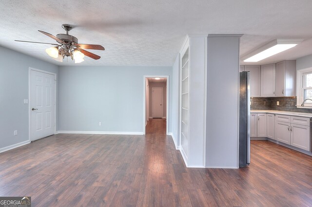 kitchen featuring tasteful backsplash, a textured ceiling, stainless steel appliances, sink, and white cabinetry