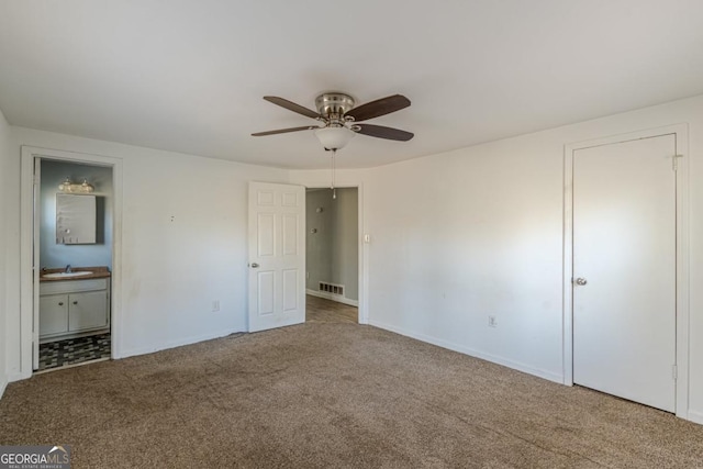 unfurnished bedroom featuring carpet flooring, ensuite bath, ceiling fan, and sink