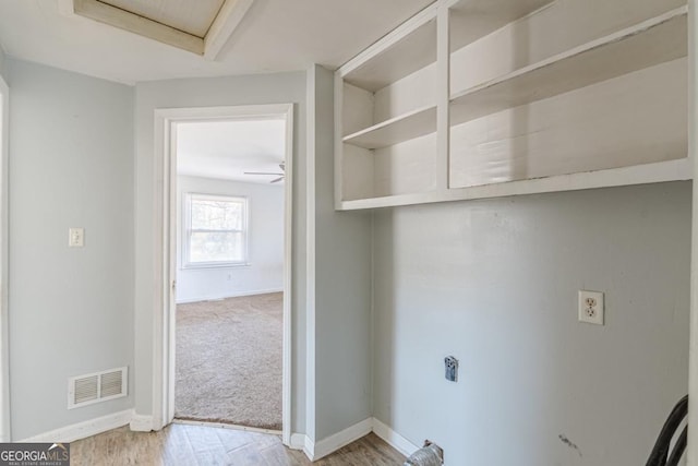 clothes washing area featuring ceiling fan and light hardwood / wood-style flooring