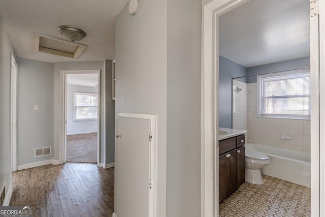 full bathroom with tiled shower / bath, hardwood / wood-style flooring, vanity, and toilet