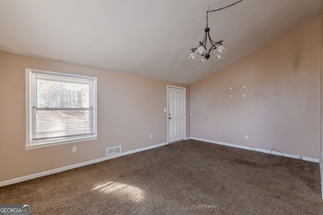 empty room featuring carpet flooring, vaulted ceiling, and an inviting chandelier