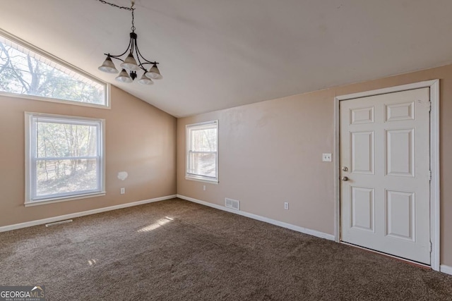 entrance foyer featuring a healthy amount of sunlight, carpet, a chandelier, and vaulted ceiling