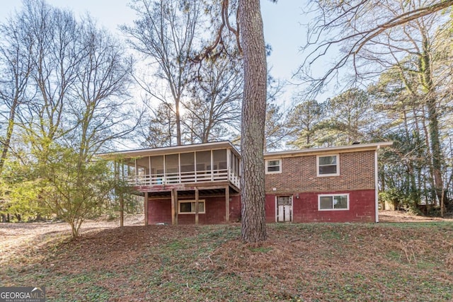 back of property featuring a wooden deck and a sunroom