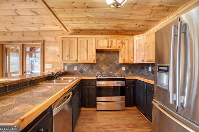 kitchen with sink, tile counters, light hardwood / wood-style floors, wood ceiling, and stainless steel appliances