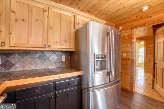 kitchen featuring tile countertops, stainless steel fridge with ice dispenser, dark wood-type flooring, and wood ceiling