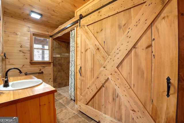 bathroom featuring wood walls, tile patterned flooring, vanity, and wooden ceiling