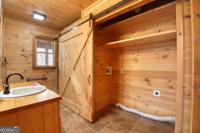 bathroom featuring vanity, wood walls, and wood ceiling