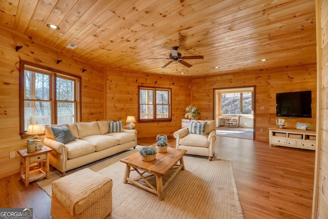 living room with wood-type flooring, ceiling fan, and wooden ceiling