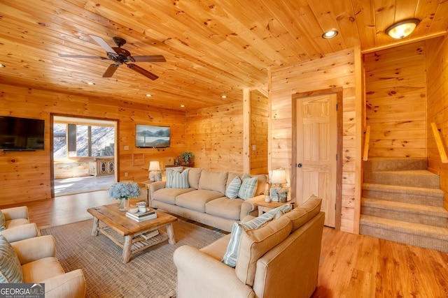 living room featuring wooden walls, light hardwood / wood-style floors, ceiling fan, and wooden ceiling