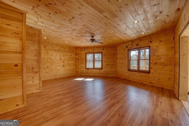 empty room with wood walls, ceiling fan, light hardwood / wood-style floors, and wood ceiling