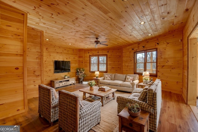 living room featuring ceiling fan, wooden ceiling, wooden walls, and light hardwood / wood-style flooring